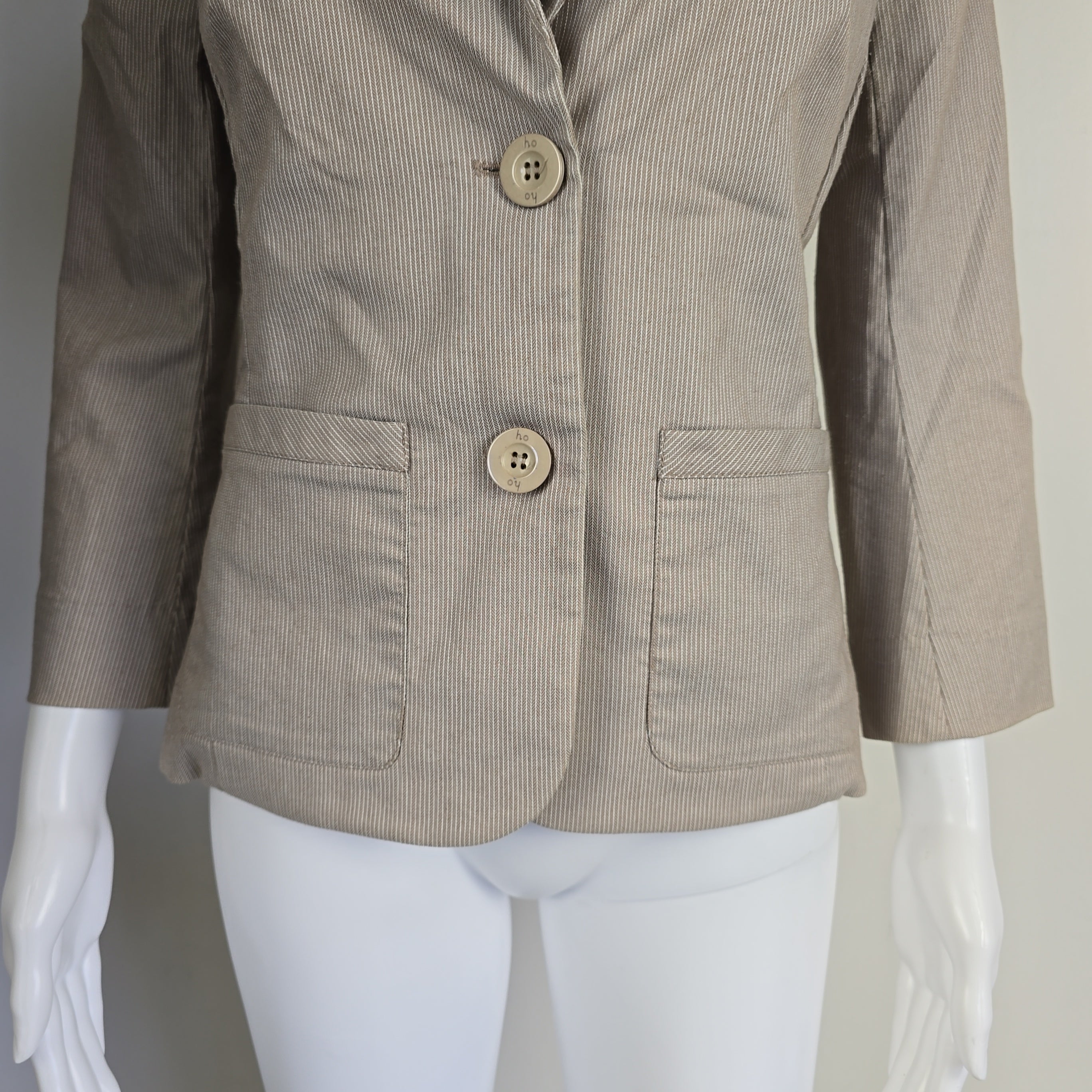 Beige striped jacket on a mannequin against a plain background