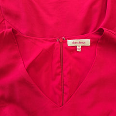 Close-up of a red garment with a brand label on a matching red background