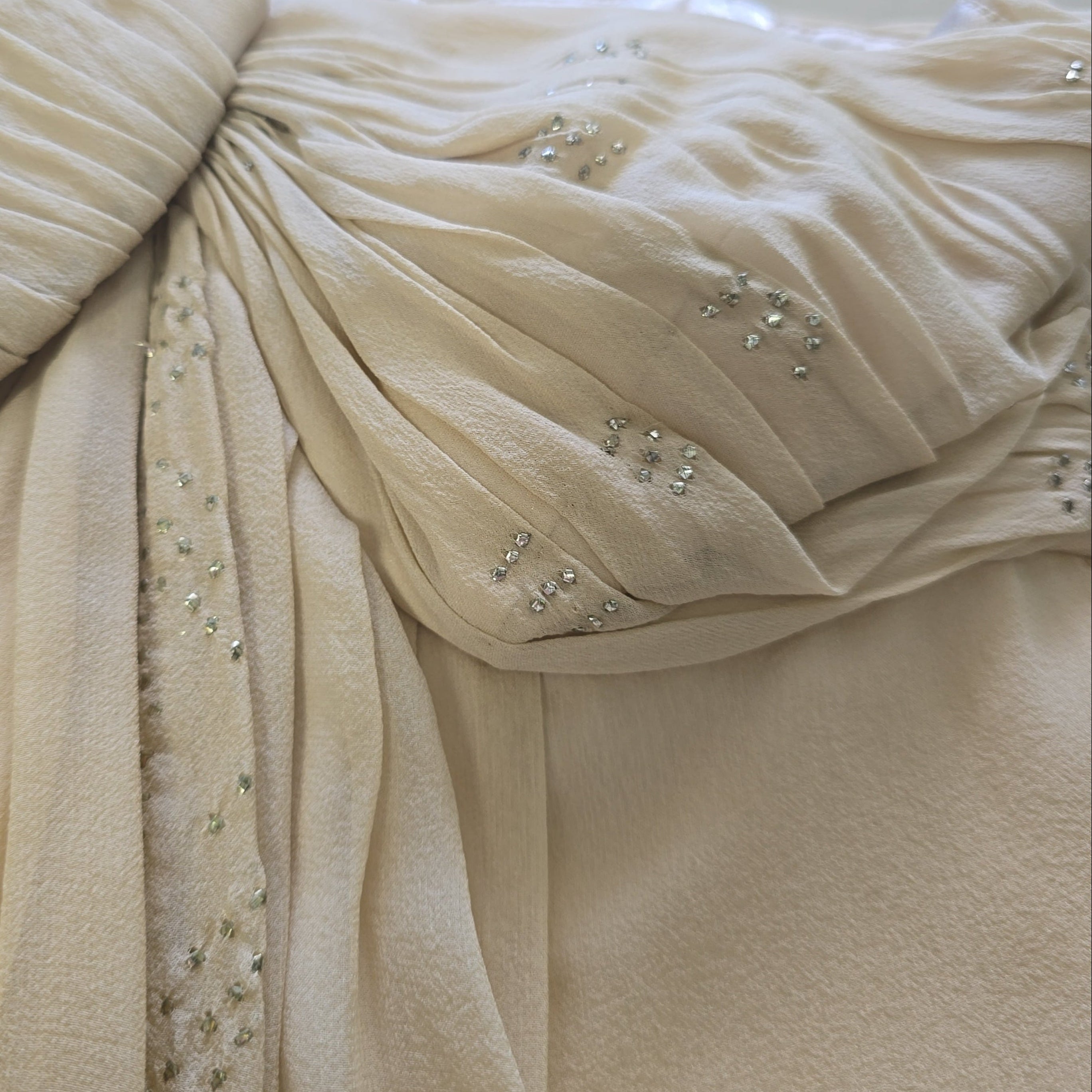 Close-up of a beige fabric with embellishments.