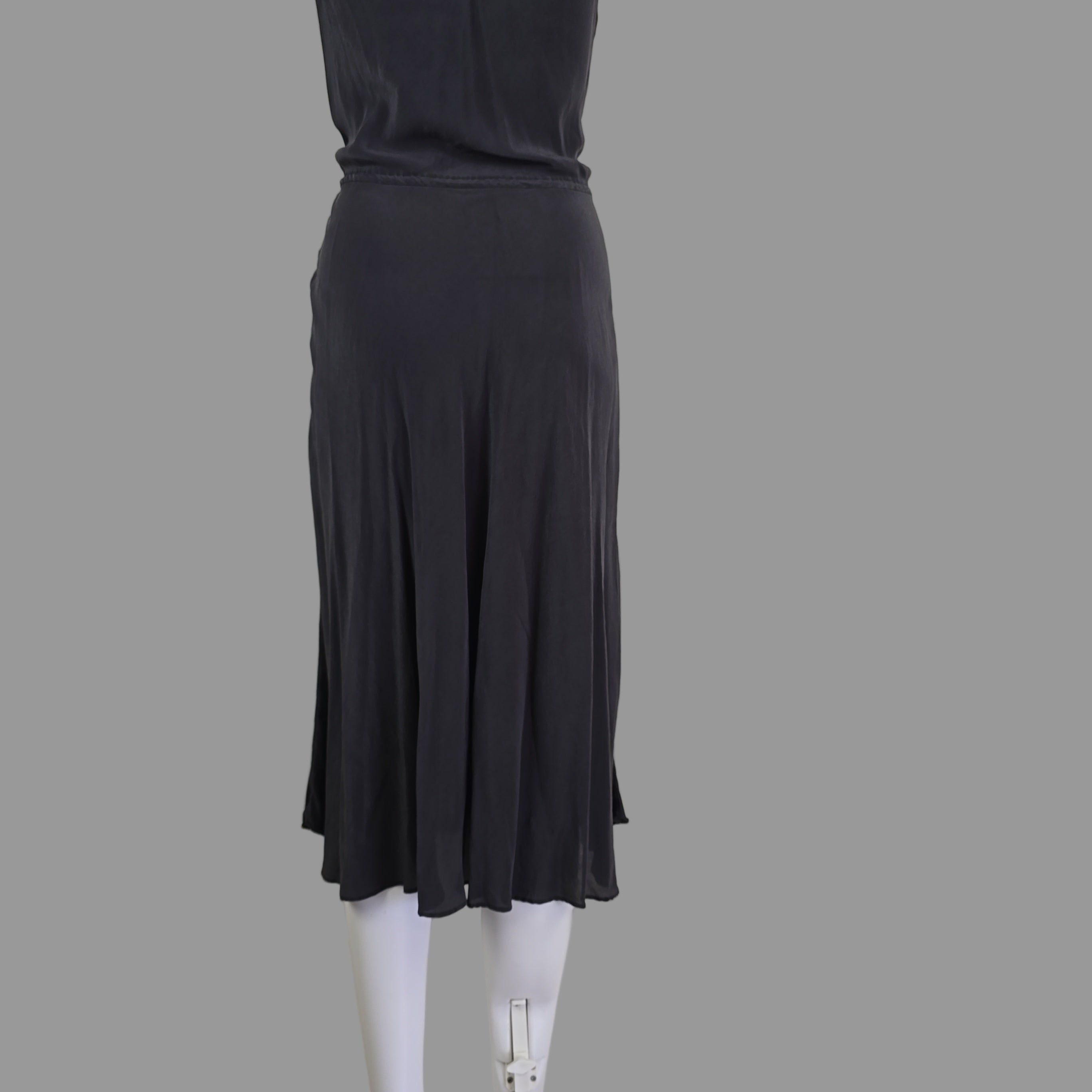 Grey dress on a white mannequin arm against a neutral background
