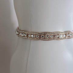 Rose gold belt on a mannequin against a white background