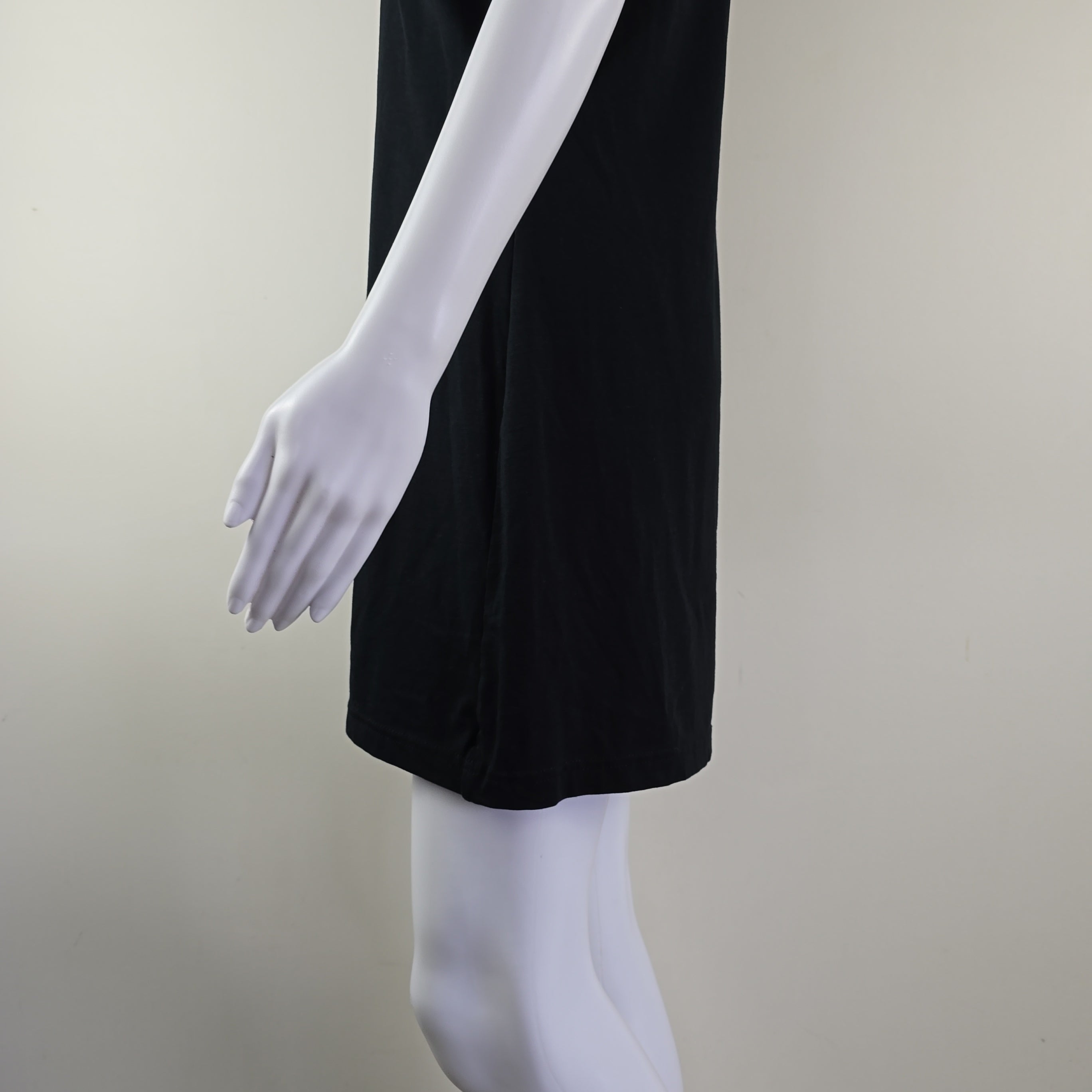 Black skirt on a white mannequin arm against a plain background