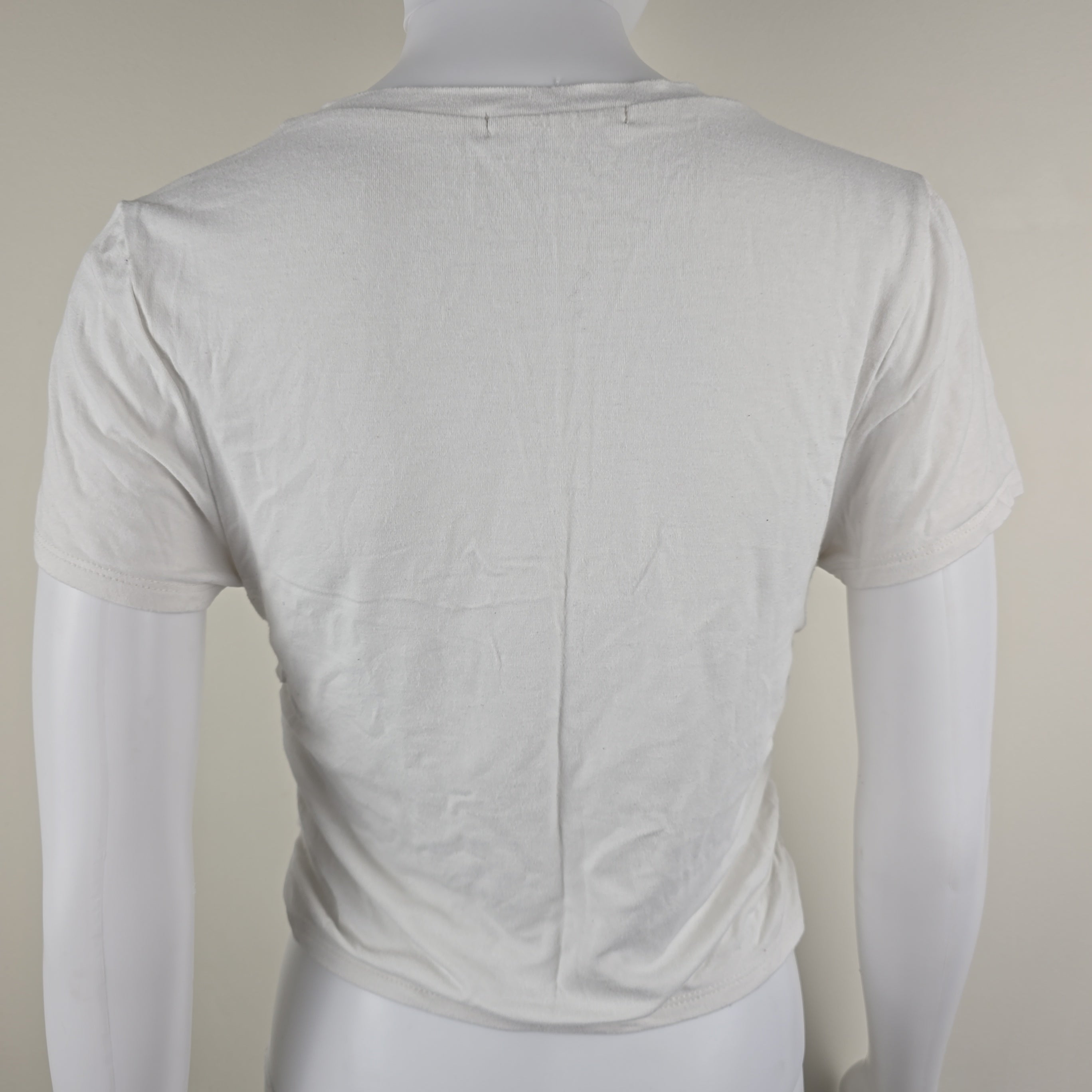 White top on a mannequin against a plain background