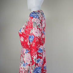 Floral-patterned ironing board cover on a mannequin against a plain background