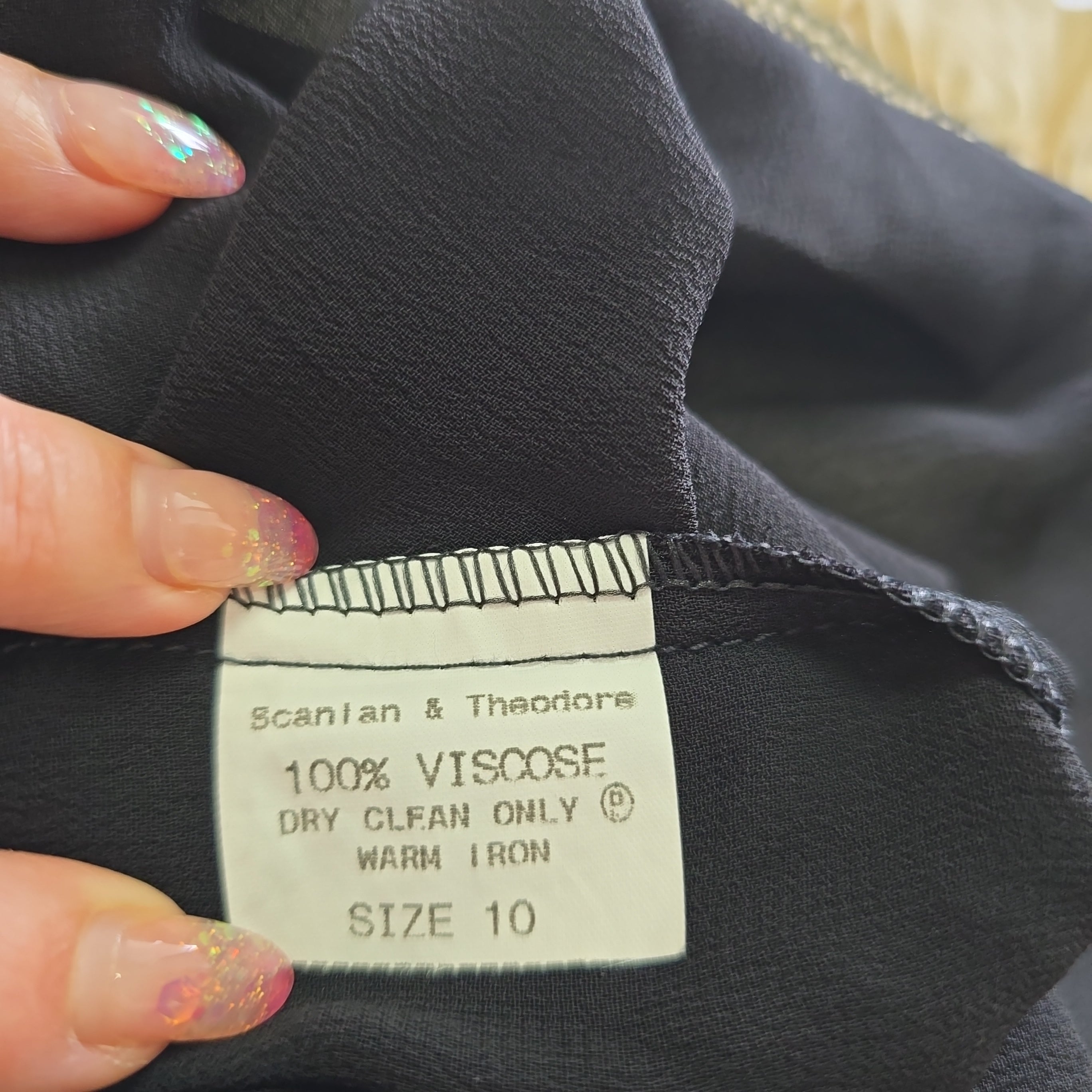 Clothing label on a black garment with visible text