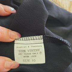 Clothing label on a black garment with visible text