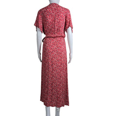 Red patterned dress on a mannequin against a white wall.
