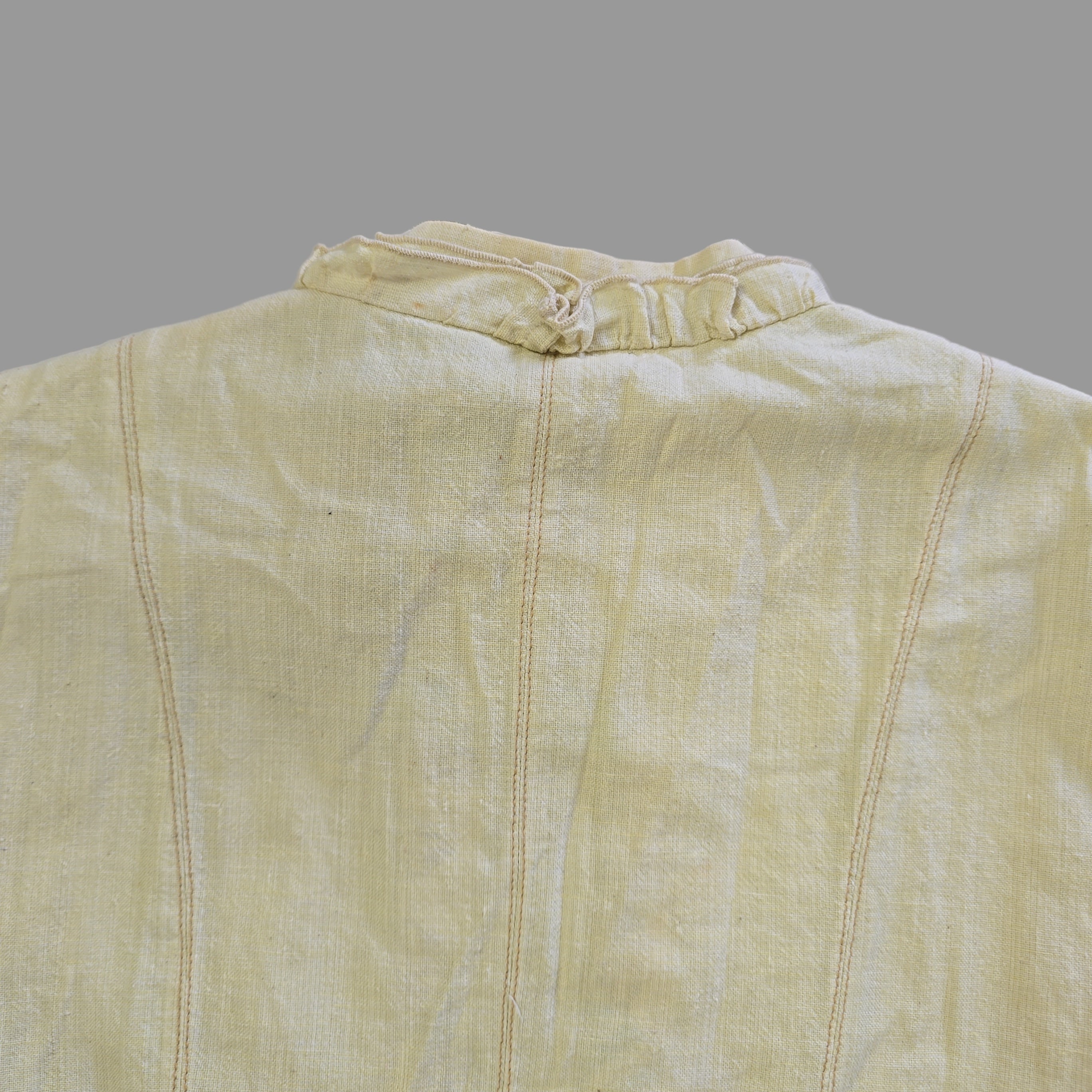 Light yellow jacket with frill details on a light background