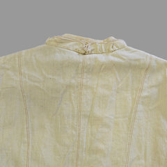 Light yellow jacket with frill details on a light background