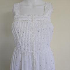 White top with intricate detailing on a beige background