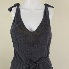 Grey lace dress on a mannequin against a beige background