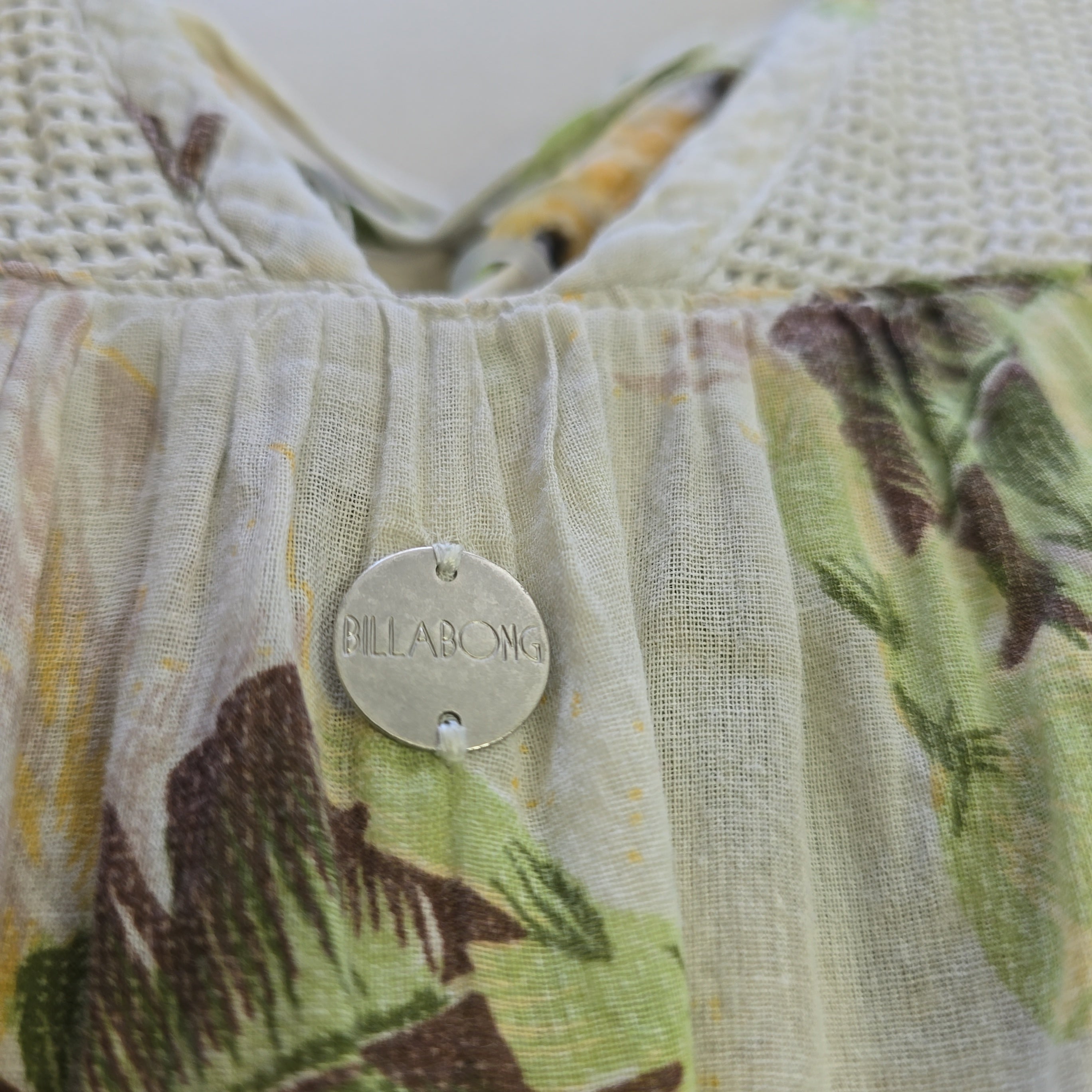 Close-up of a fabric product with a brand label, featuring a floral pattern.