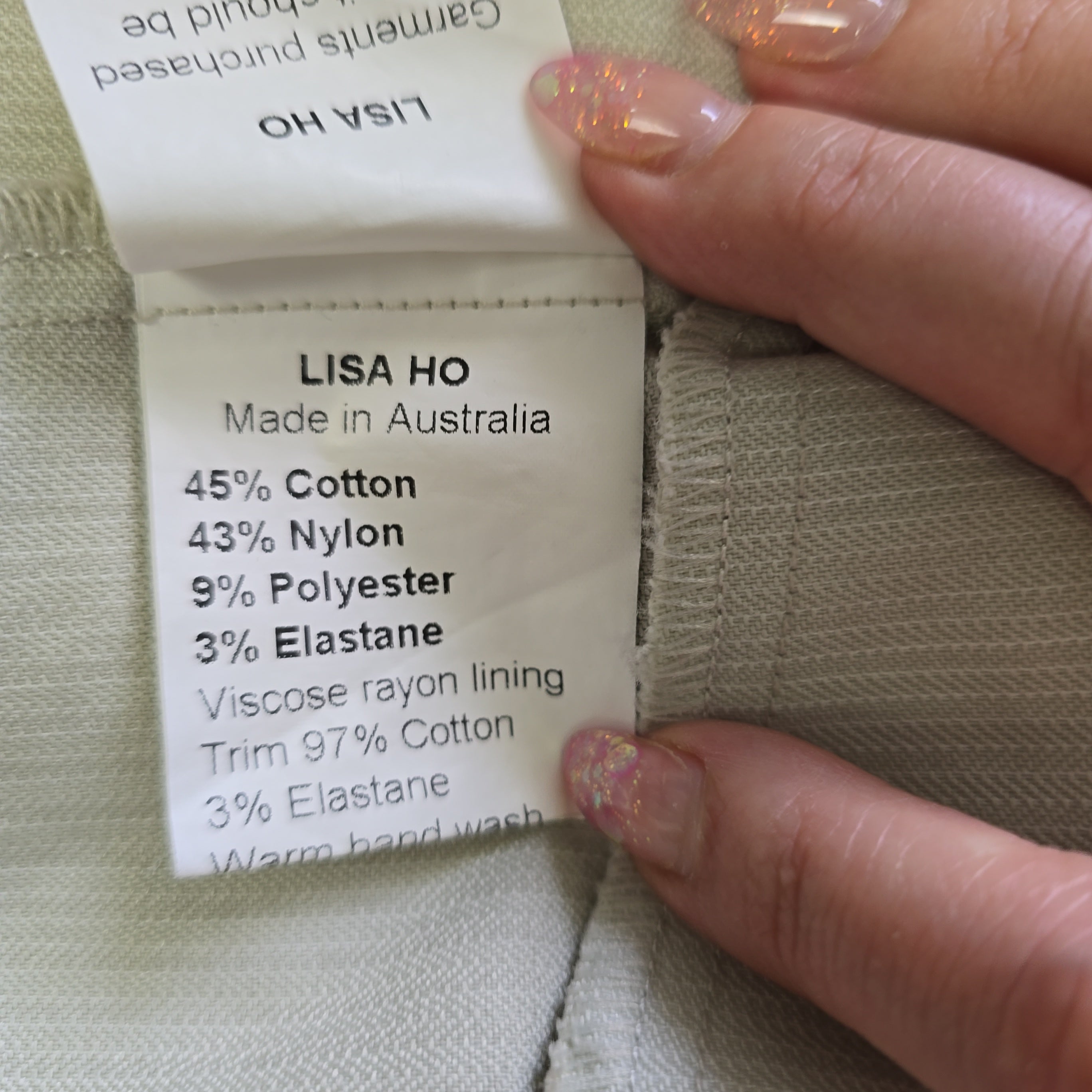 Close-up of a label on a garment with 'Lisa Ho' branding and fabric composition details.