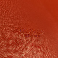 Close-up of a red textured surface with 'OROTON' branding.
