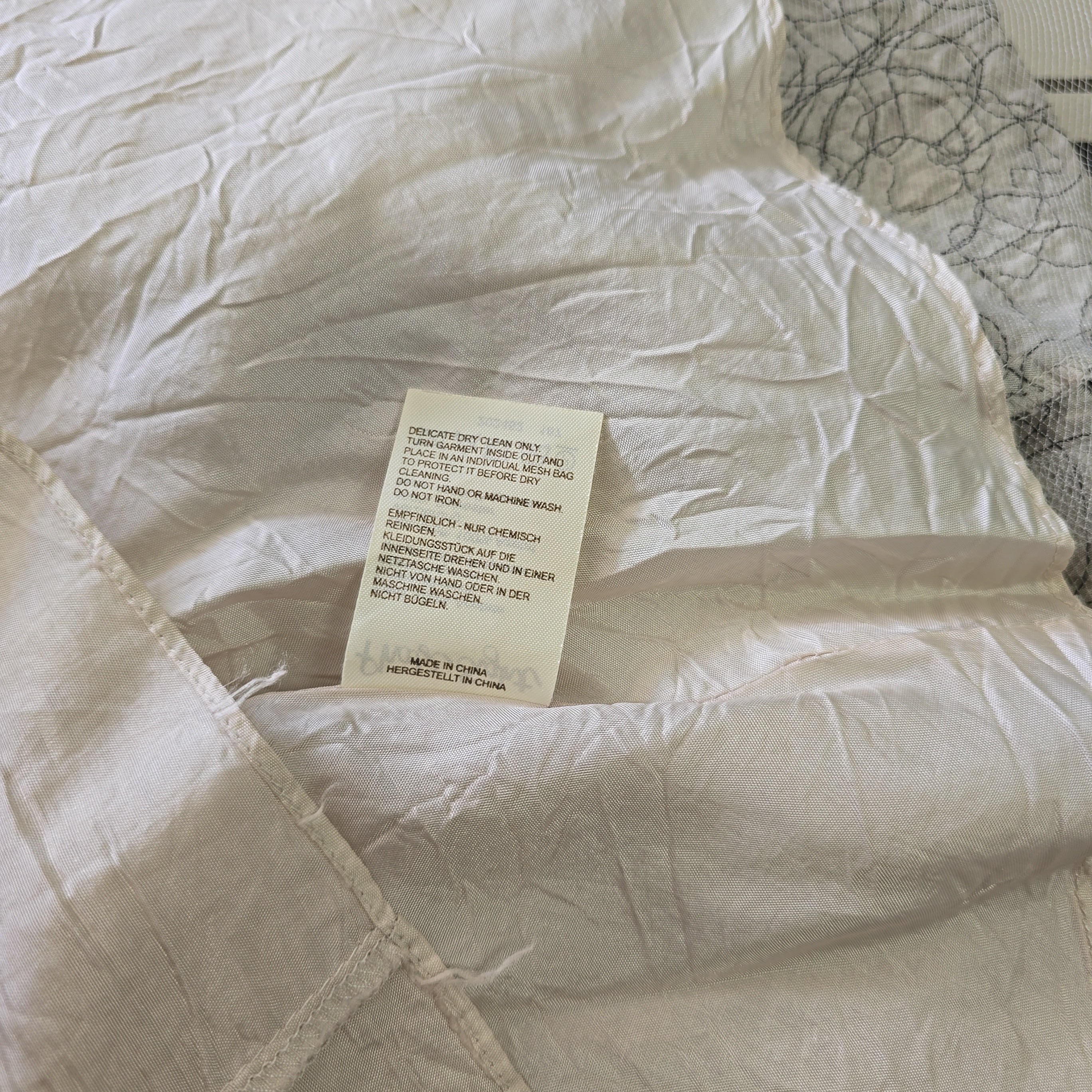 Close-up of a white comforter with a tag on a textured surface