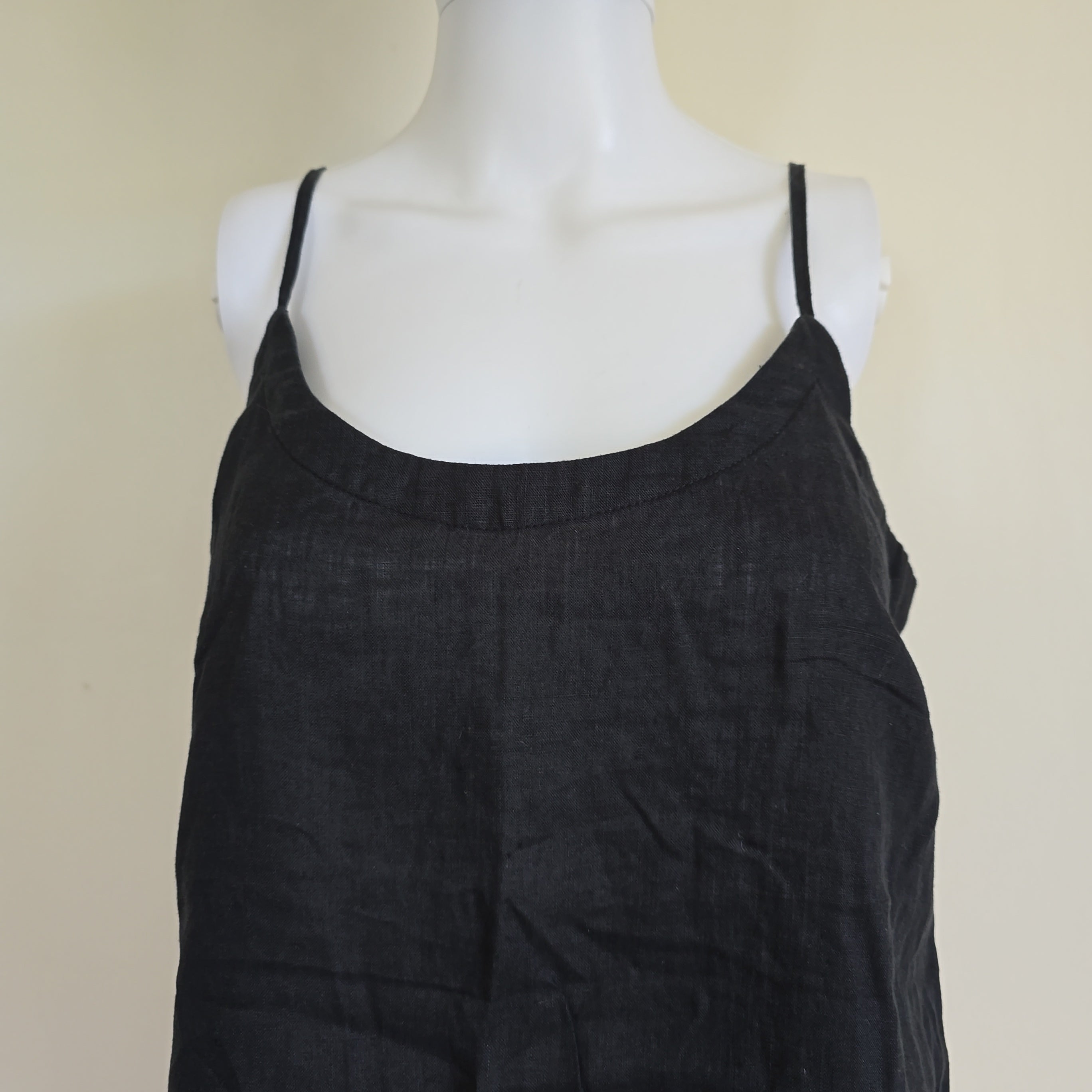 Black top on a mannequin against a beige background
