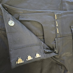 Close-up of black pants with silver buttons and zippers.