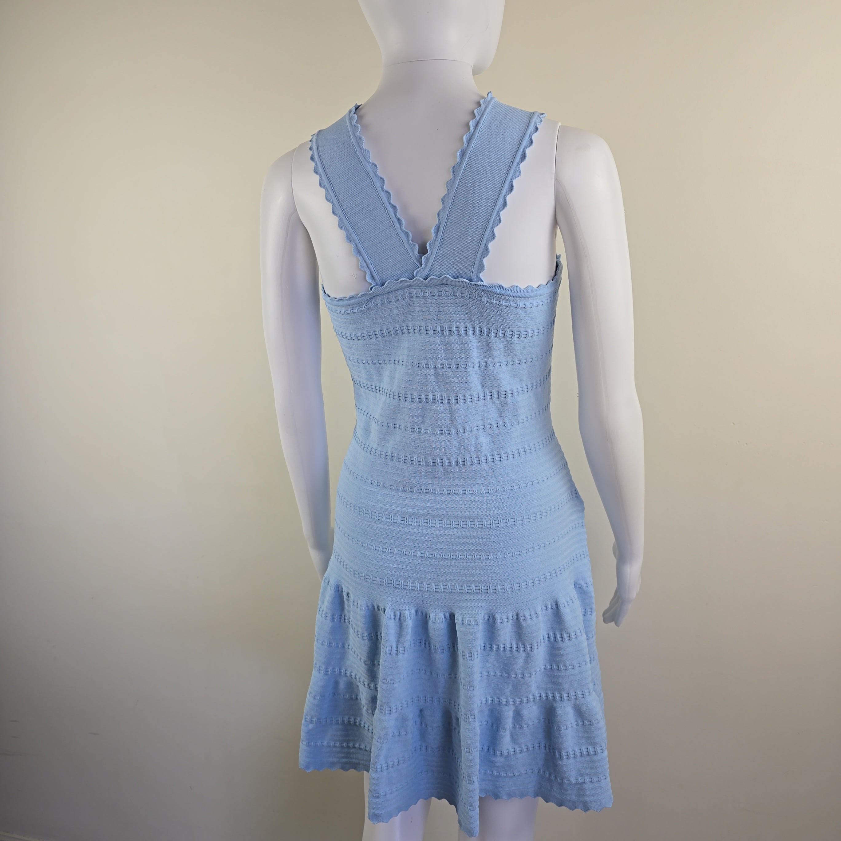 Light blue knitted dress with ruffled straps on a mannequin against a plain background