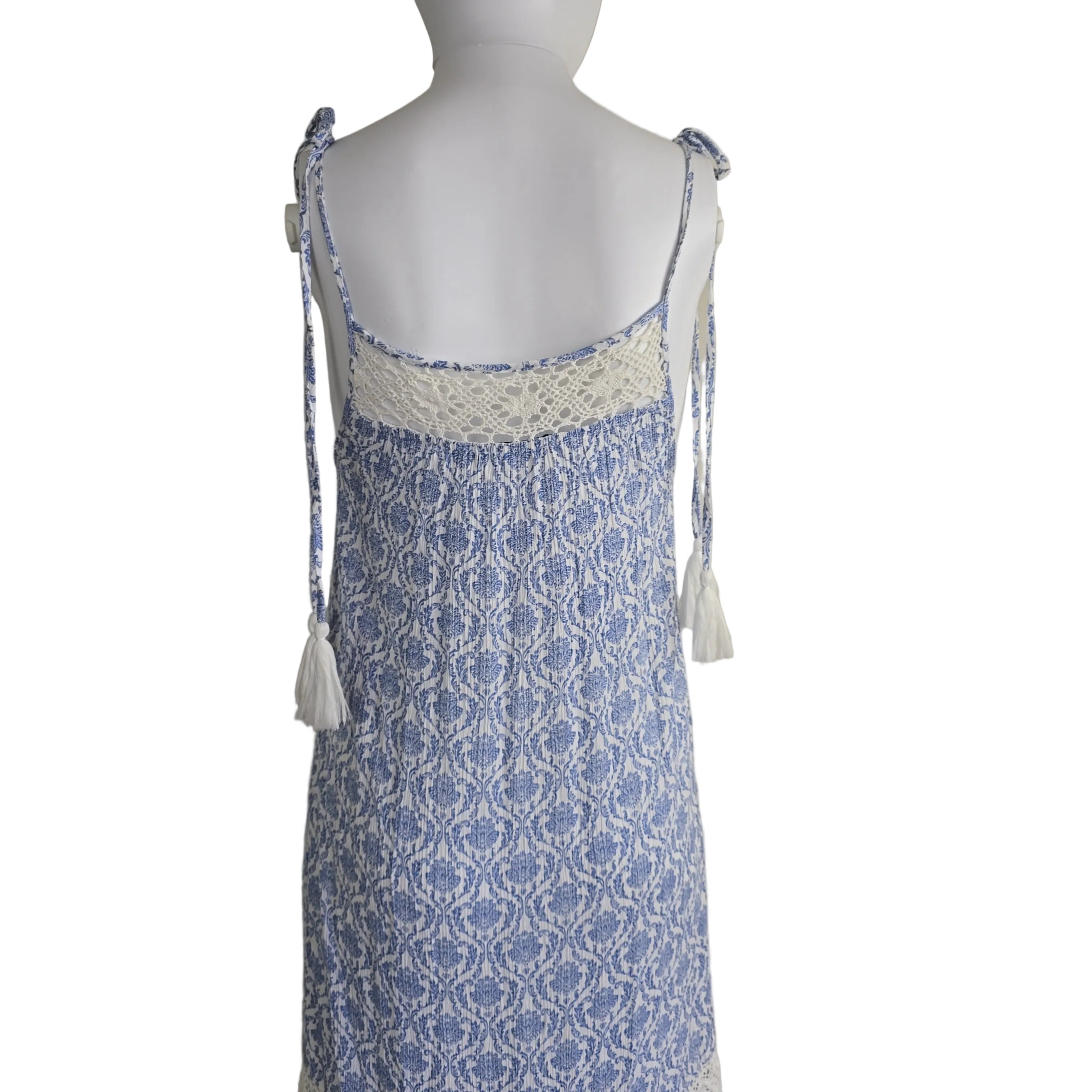 Mannequin wearing a blue and white patterned dress with lace details on a plain background