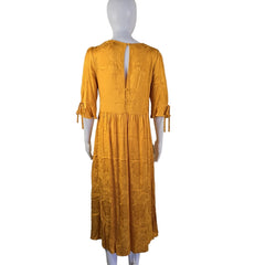 Yellow pleated dress on a mannequin against a white background