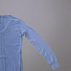 Blue sleeveless top on a tiled floor