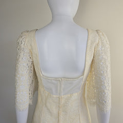 Mannequin wearing a beige lace-trimmed dress with a neutral background