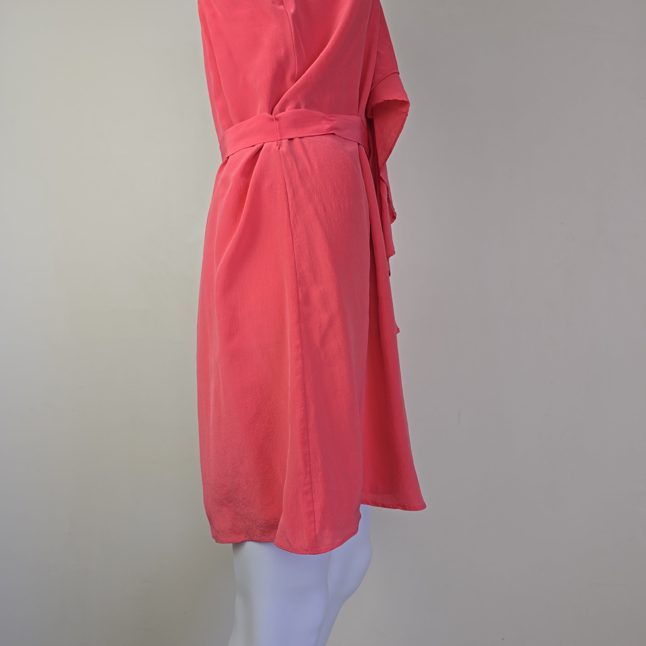 Pink dress on a mannequin against a plain background
