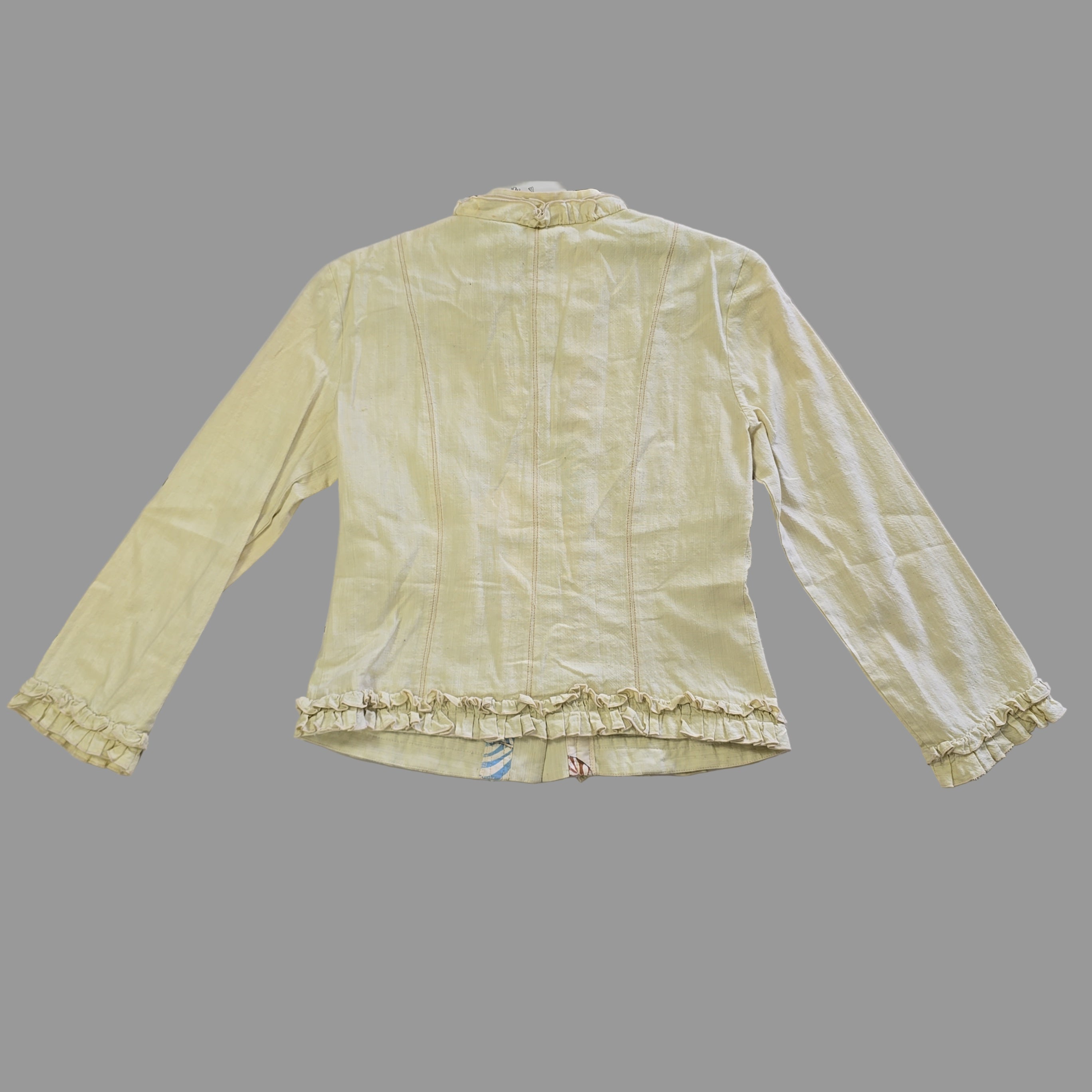 Light yellow jacket with frill details on a light background
