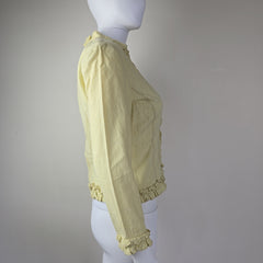 Light yellow jacket with frill details on a light background