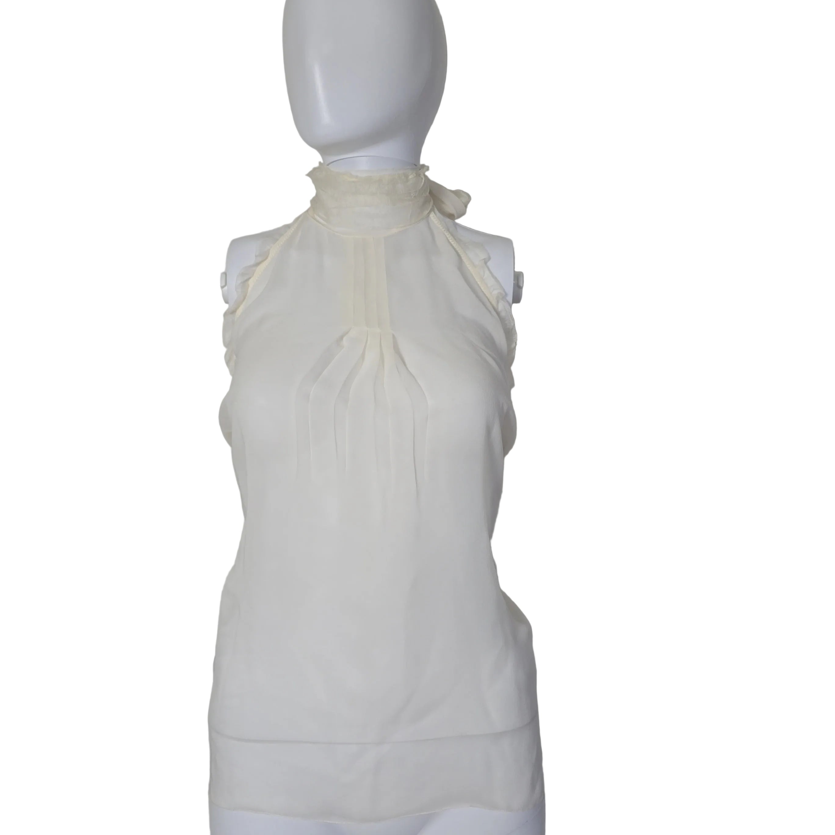 White top on a mannequin against a plain background