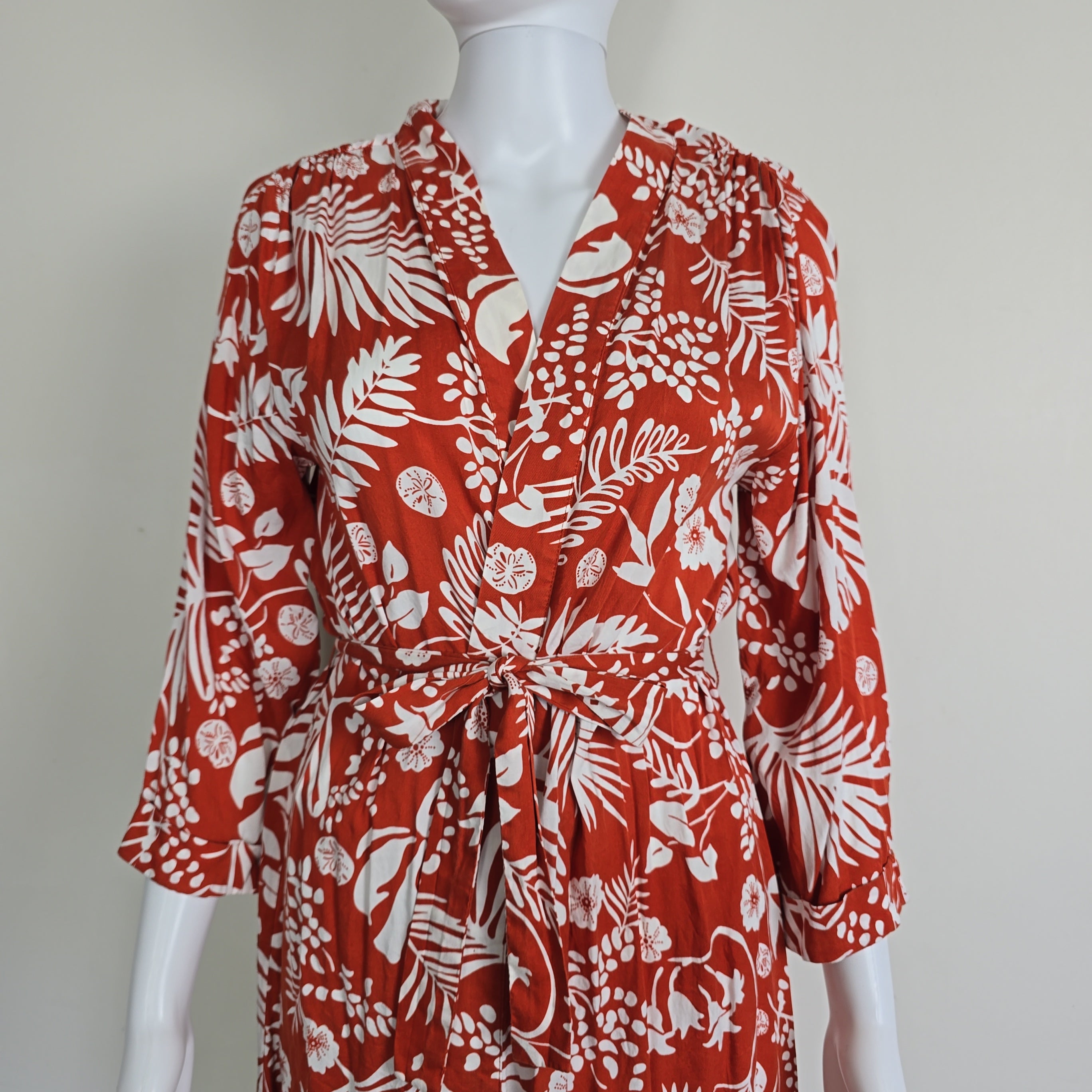 Red and white floral patterned dress on a mannequin against a plain background