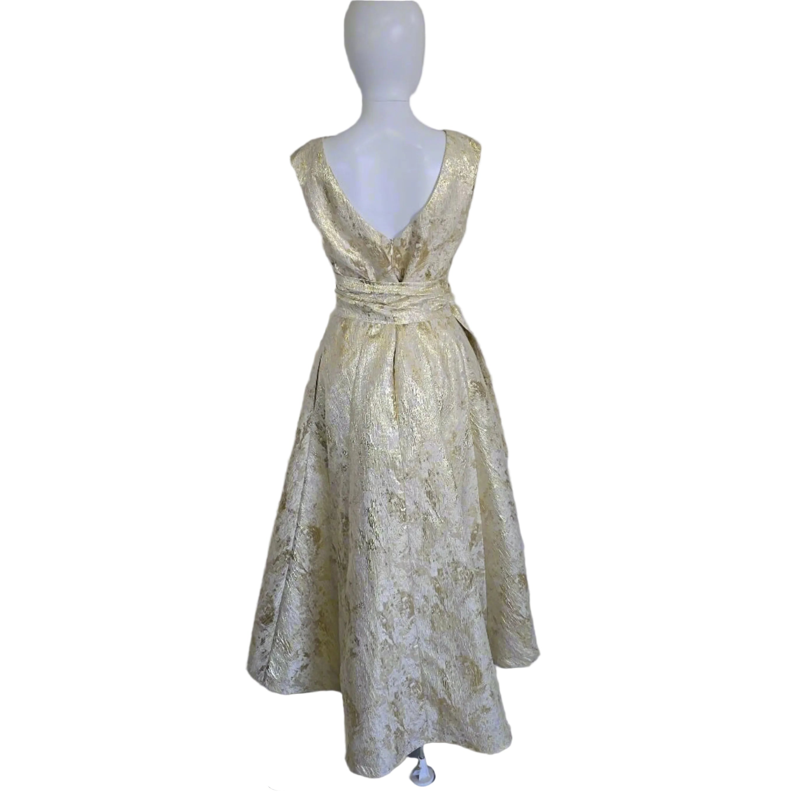 Gold lace dress on a mannequin against a plain background