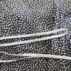 Close-up of a fabric with a subtle pattern and white drawstrings.