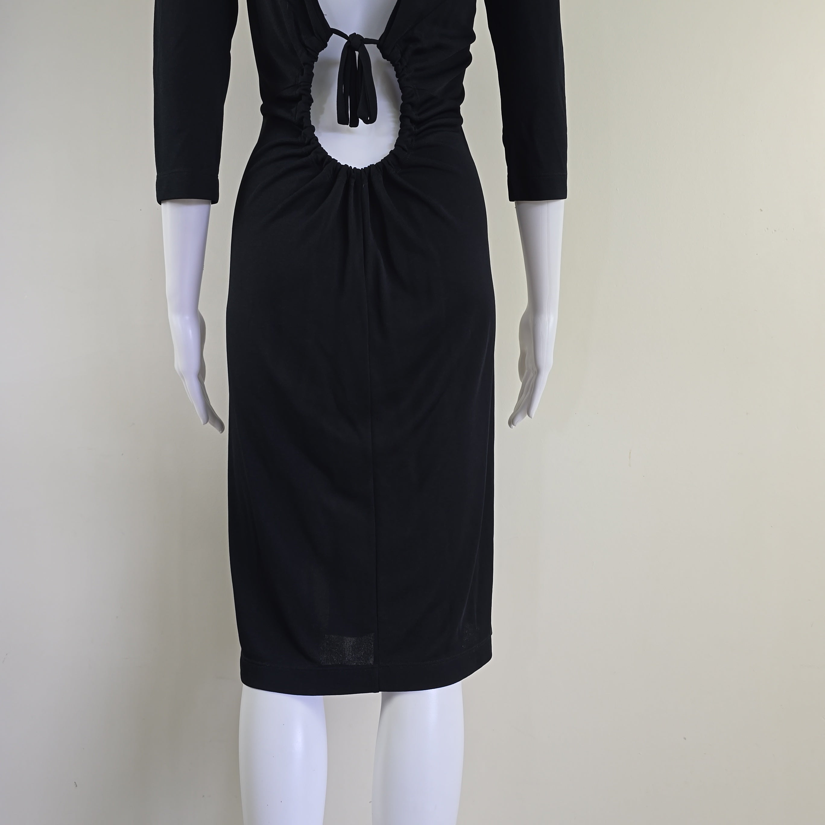 Black dress on a mannequin against a plain background