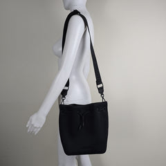 Black bag with a strap on a mannequin against a plain background