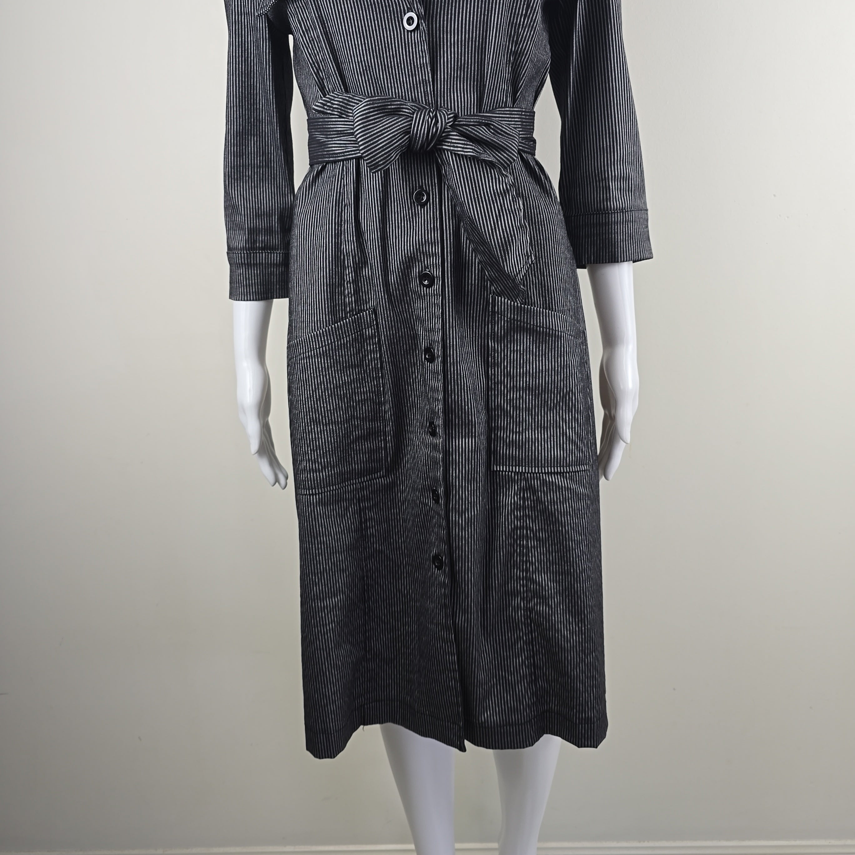Black denim dress on a mannequin against a plain background