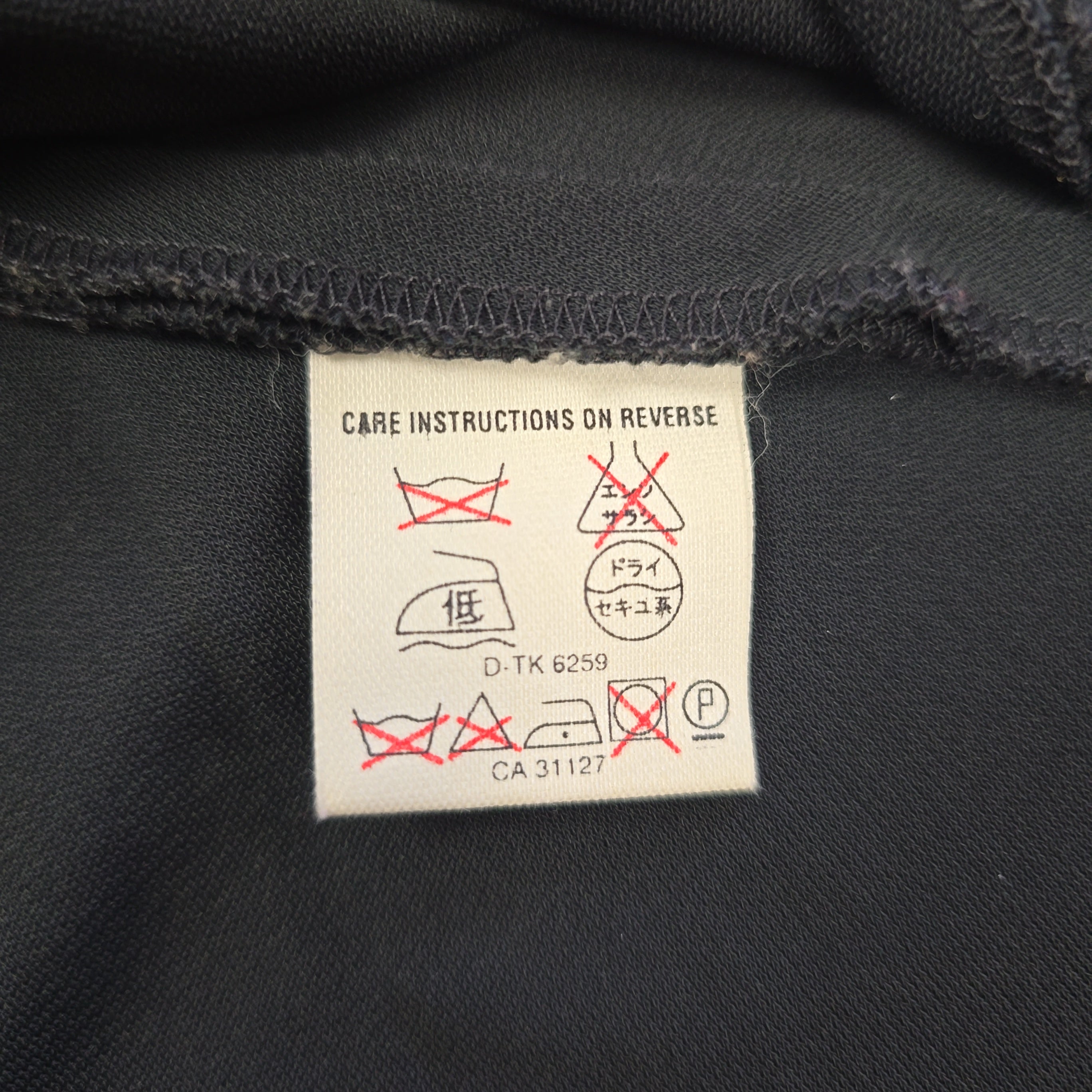 Care label on a black fabric background