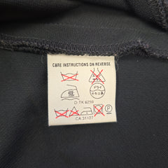 Care label on a black fabric background