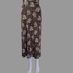 Folded brown fabric with leaf pattern on a mannequin arm against a white wall.
