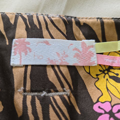 Close-up of a fabric with tiger stripe and floral pattern, featuring a visible brand tag.