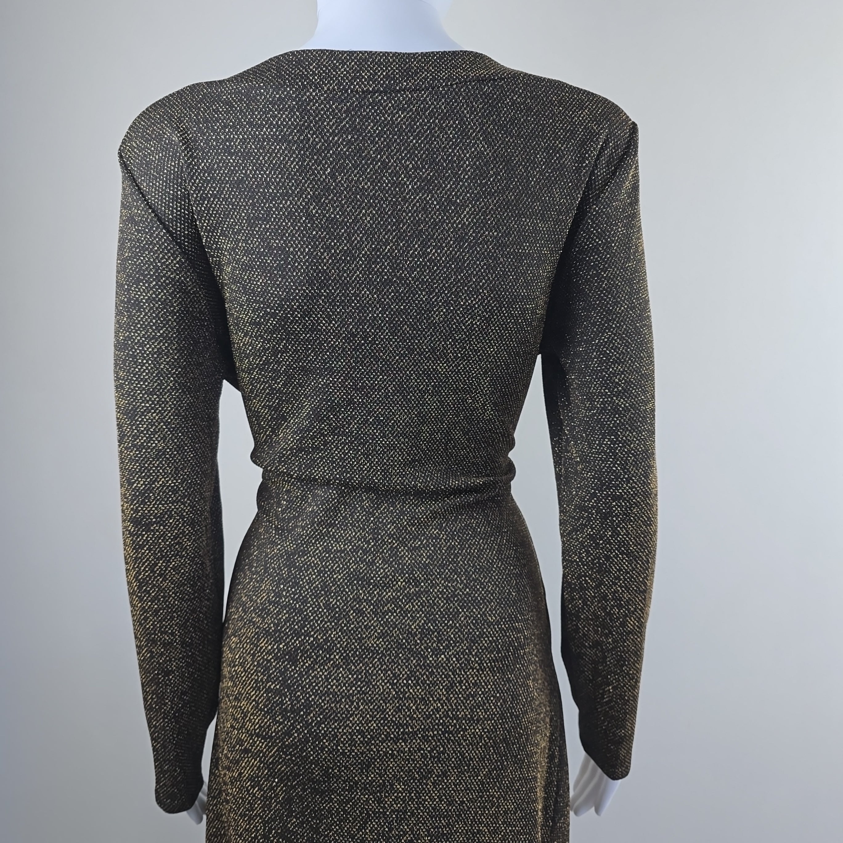 Black and gold textured dress on a mannequin against a light gray background