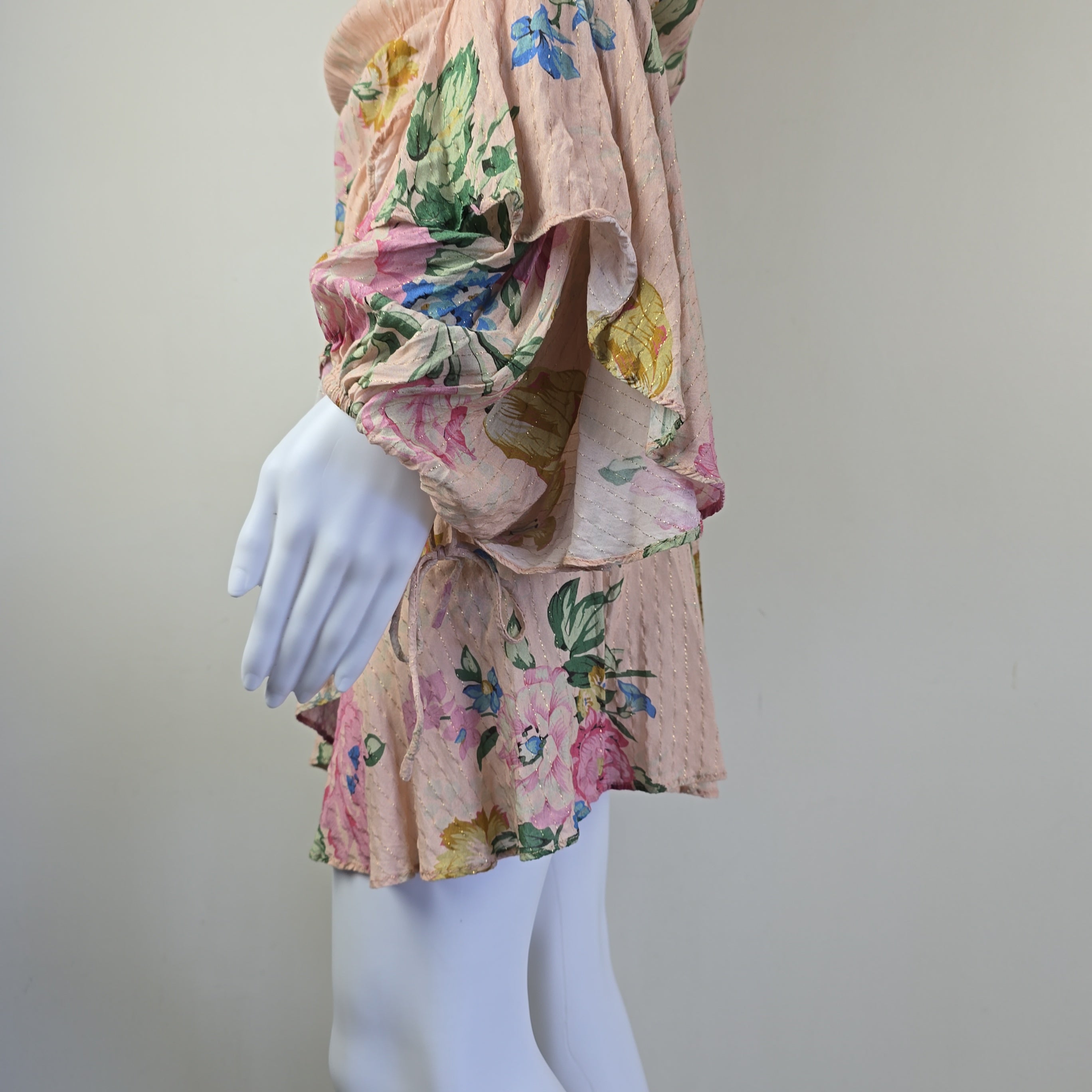 Floral-patterned fabric on a mannequin arm with a plain background