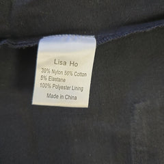 Woven label on a dark fabric with 'Lisa Ho' branding and material details.