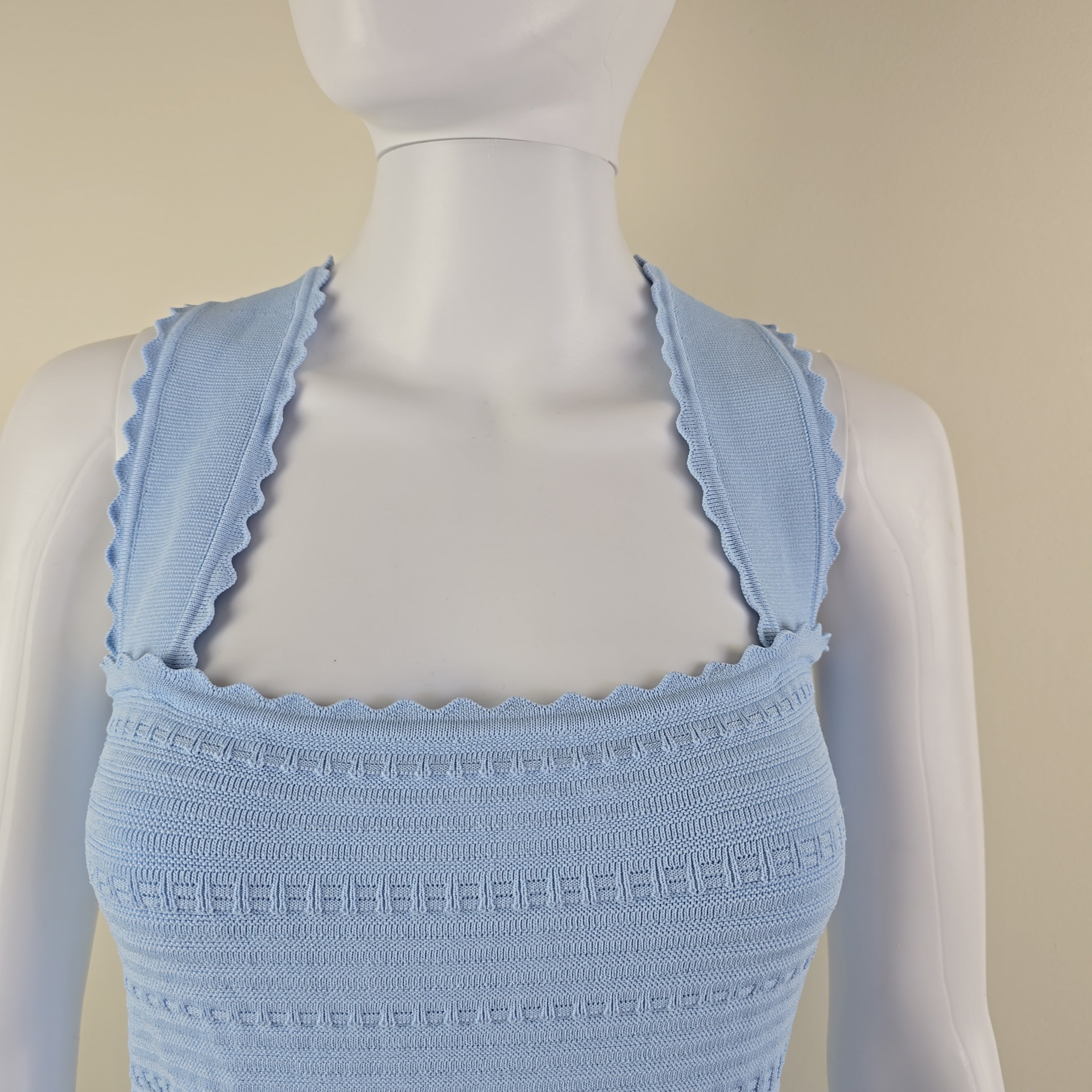 Light blue textured btop on a mannequin against a beige background