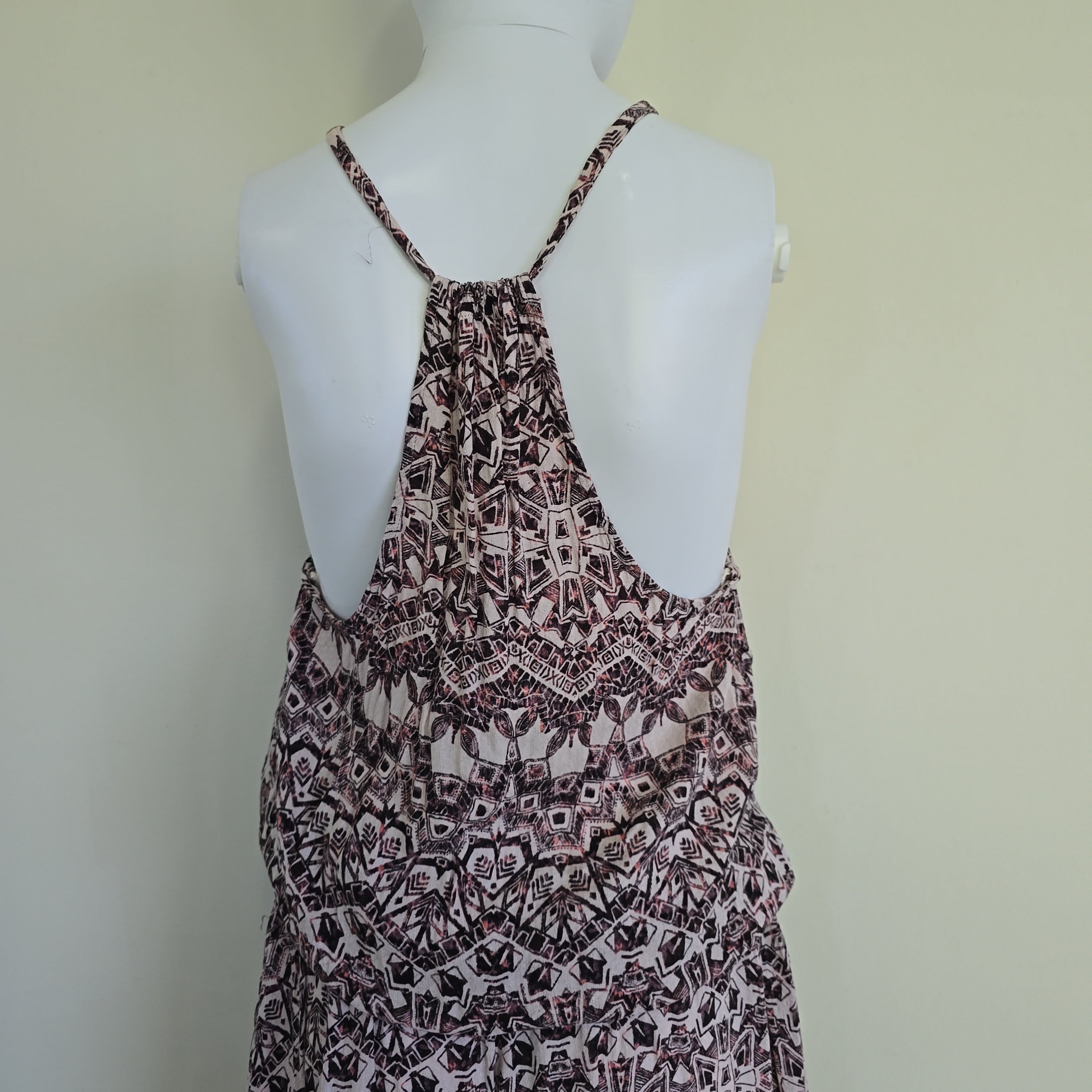 Patterned dress on a mannequin against a plain background