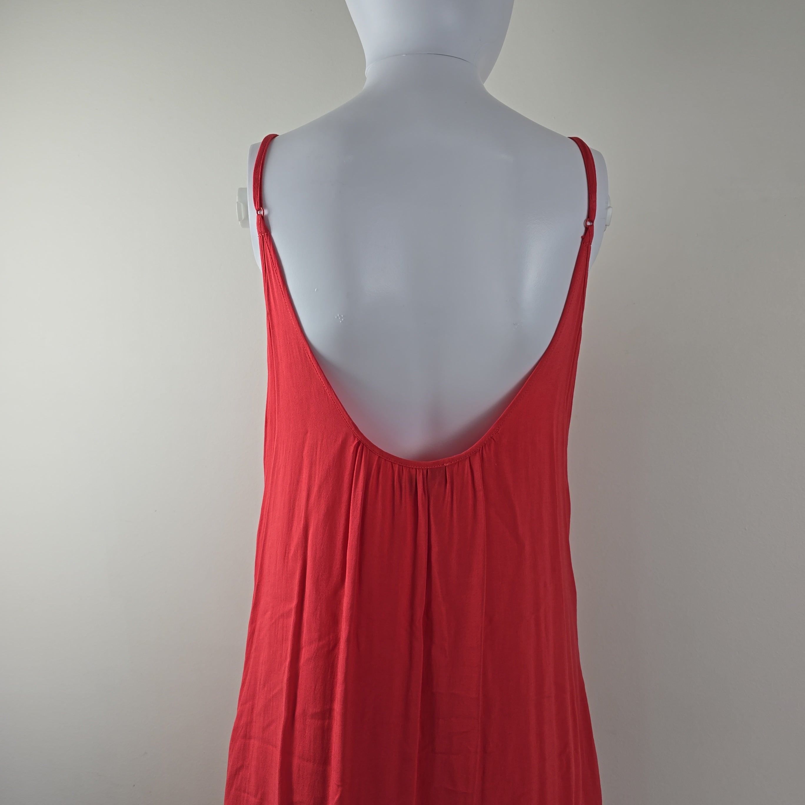 Red dress on a mannequin against a plain background