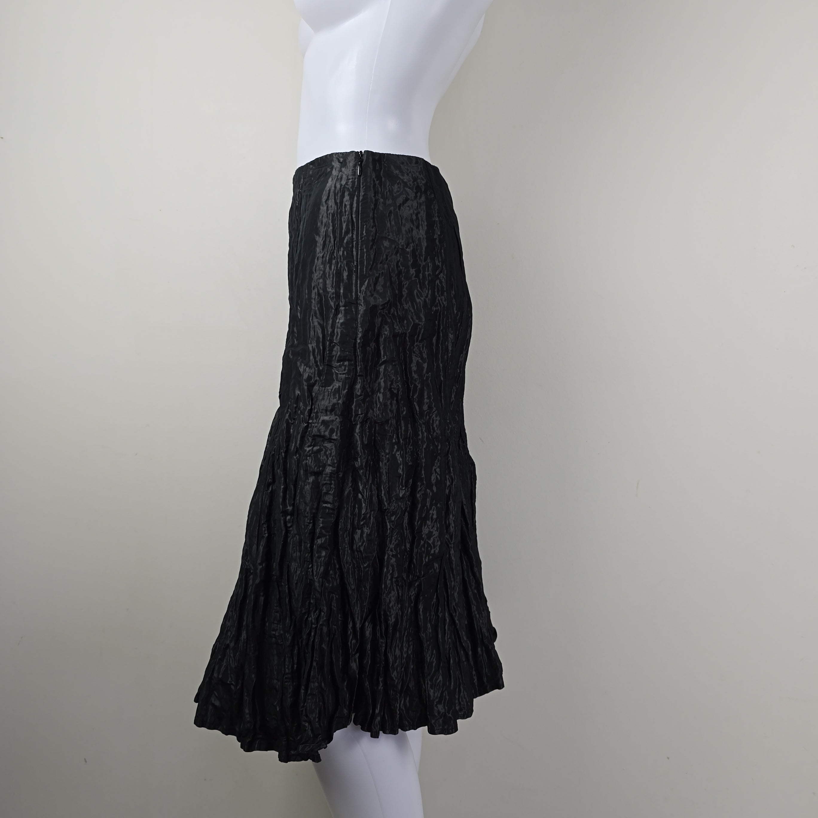 Black textured skirt on a mannequin against a plain background