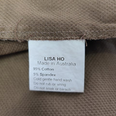 Fabric label on a brown garment with 'Lisa Ho' branding and material details.