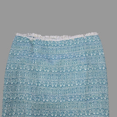 Blue patterned skirt with white fringe on a tiled floor