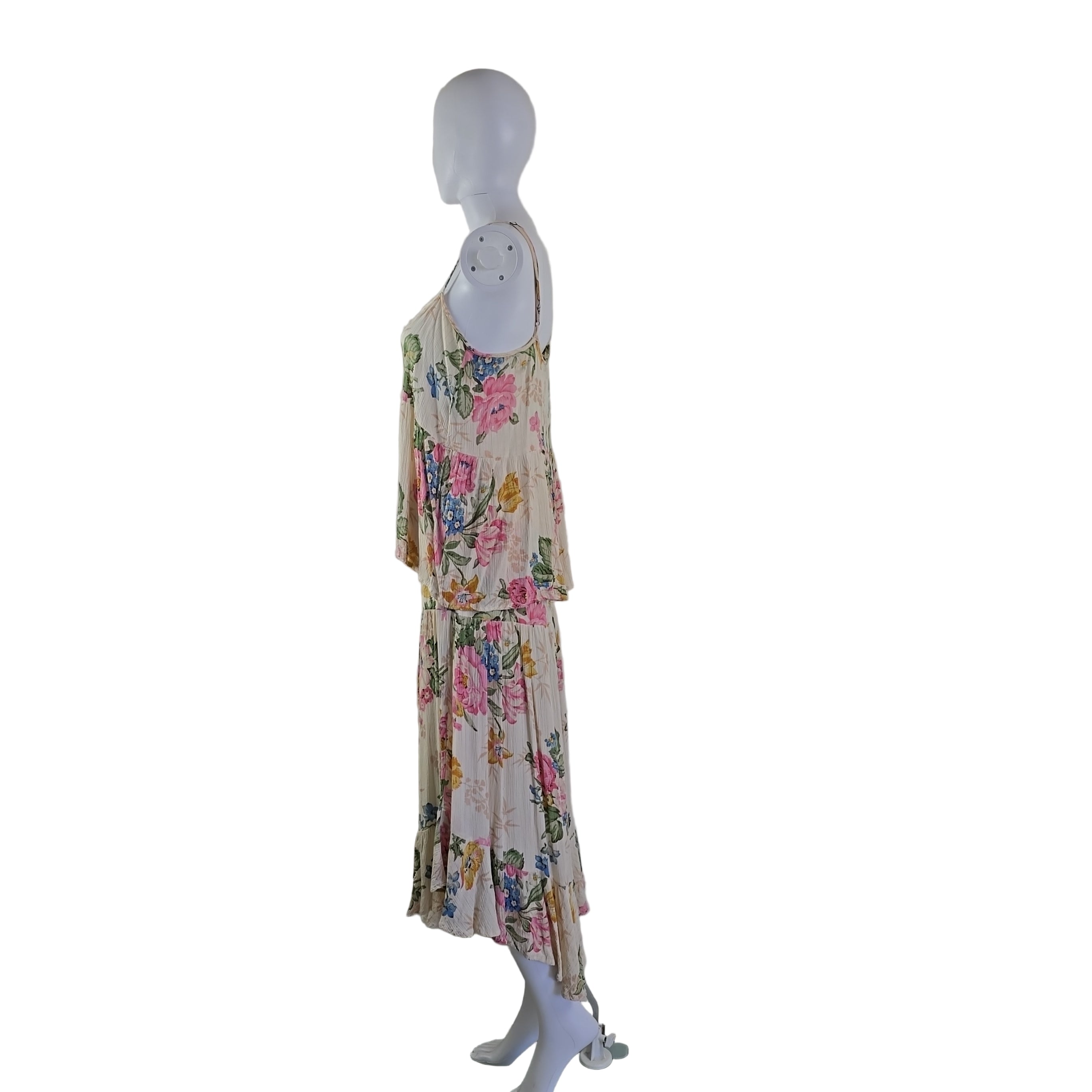 Floral top and skirt hanging on a white mannequin against a neutral wall.